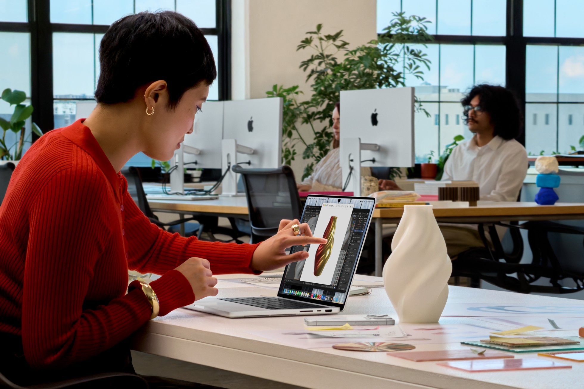 De nieuwe MacBook Pro met PROLED XDR-display in gebruik op een bureau, met aanraakbediening